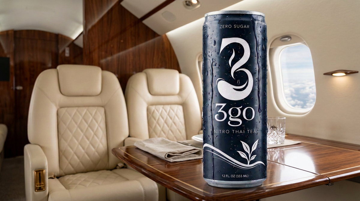 A cold can of 3go Nitro Thai Tea on a wooden table inside a luxury private jet cabin.